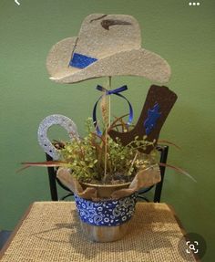 a potted plant sitting on top of a wooden table next to a cowboy hat