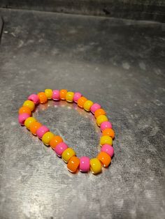 This orange, yellow and pink beaded bracelet is fun for everyone! Great for parties, concerts and more! Pink Beaded Bracelet, Pink Beaded Bracelets, Yellow And Pink, Pink And Yellow, Beaded Stretch Bracelet, Orange Pink, Stretch Bracelet, Orange Yellow, Stretch Bracelets