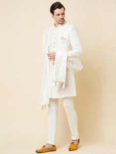 This Royal White Embroidered sherwani will instantly give an elegant look. Made from polyester cotton fabric, this 3 piece sherwani set features a white royal sherwani, front buttons fastening, designer cuff buttons, pocket square, and a mandarin collar. This white base sherwani has beautiful subtle gold Jaal thread-sequin embroidery work all over. It is paired with white churidar pants and matching dupatta. An ideal outfit for traditional & special events.

Size Chart For Men





	
	
					Men' White Nehru Jacket With Traditional Drape For Groom, White Nehru Jacket For Groom With Traditional Drape, Elegant White Cotton Churidar, White Kurta With Zari Work For Groom, White Zari Work Kurta For Groom, White Bandhgala For Groom With Traditional Drape, Elegant Cotton Sherwani For Wedding, White Traditional Wear With Resham Embroidery For Groom, White Resham Embroidery Traditional Wear For Groom