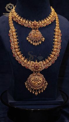 a gold necklace and earrings set on display