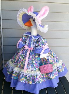 a doll is sitting on a bench wearing a dress