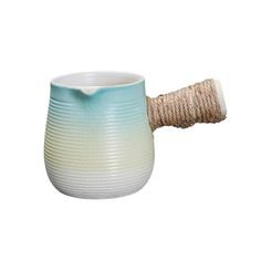 a white and blue vase with a rope wrapped around it