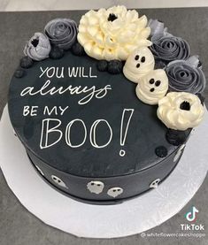 a black cake with white frosting and flowers on top that says you will always be my boo