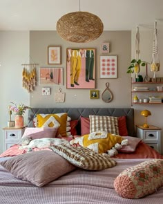 a bed room with a neatly made bed and lots of pictures on the wall above it