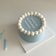 a blue birthday cake with white frosting on top and a toothbrush next to it