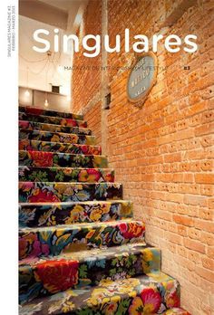 the front cover of singulares magazine with colorful stairs and brick wall in background