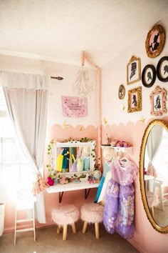 a room with pink walls and pictures on the wall