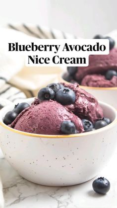 two bowls filled with blueberry ice cream on top of a marble counter next to a striped towel