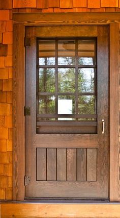 the front door is made of wood and has a glass paneled window on it