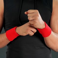 a man in black shirt holding his arm with red wristbands