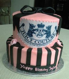 a pink and black birthday cake sitting on top of a table