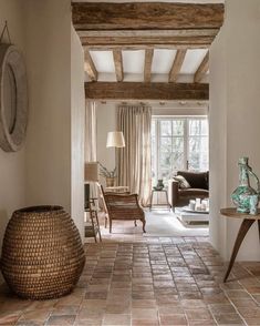 a living room filled with lots of furniture next to a wall covered in wood beams