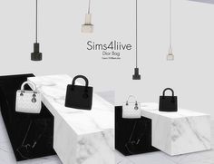 three white and black handbags are on display at the same time, with different lighting fixtures hanging above them