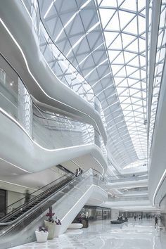 the interior of an airport with stairs and escalators in white marble flooring