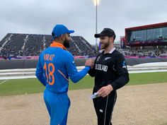 two men standing next to each other on a field