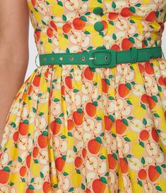 This adorable 1950s style swing dress is crafted in a smooth woven fabric that dances with charming red apples throughout the yellow backdrop. The self tie halter is framed by the sleeveless silhouette, while the full swing skirt is cinched by a red belt. Crinoline added for volume, sold separately. Available in sizes XS-5X while supplies last. Vintage Like Dresses, Apple Print Clothing, Belted Vintage Dress, Vintage Dresses Halter, Vintage Colour Palette 1950s, Vintage Color Palette 1950s, 50 Fashion Vintage 1950s, Educator Aesthetic, Kooky Fashion