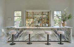 a marble bar with three stools next to it