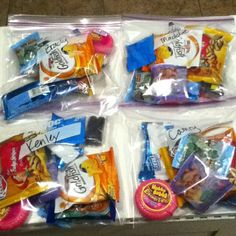 four packaged snacks in plastic bags sitting on the floor next to each other, including candy bars and candies