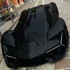 a black sports car is parked on the side of the road in front of a building