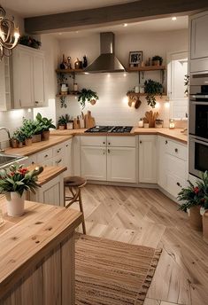 a kitchen filled with lots of wooden counter tops and white cupboards next to a stove top oven