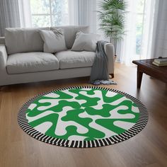 a living room with a white couch and green circular rug on the floor in front of a window