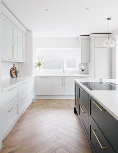 a large kitchen with white cabinets and wood flooring on the walls, along with an island in the middle