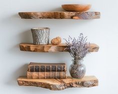 three wooden shelves with books and vases on them