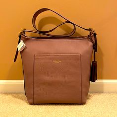 Coach Bucket Style Handbag, Mauve Colored Pebbled Leather, Gold Hardware, Adjustable Shoulder Strap, Tassel Detail On Side, Zip Closure, Roomy Interior, Interior Zip Pocket And Two Additional Interior Pockets, External Pocket, Brand New, Never Used, Tags Attached. 13 X 12 X 6. Storage Bag Included Coach Leather Bucket Bag, Coach Textured Leather Shoulder Bag For Travel, Coach Textured Leather Hobo Bag For Travel, Coach Textured Leather Travel Bag, Coach Rectangular Hobo Bag For Travel, Coach Textured Leather Travel Shoulder Bag, Coach Rectangular Hobo Travel Bag, Everyday Coach Bucket Bag With Gold-tone Hardware, Coach Rectangular Hobo Bag For On-the-go