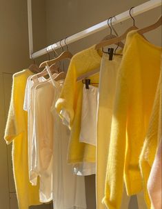 yellow and white sweaters hanging on clothes racks