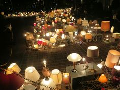 a room filled with lots of lamps on top of a tiled floor next to each other