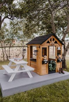 a picnic area with a table, bench and potted plants