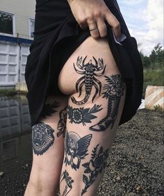 a woman's legs with tattoos on them and her leg in the shape of scorpions