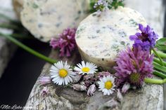 some flowers and cheese on a piece of wood