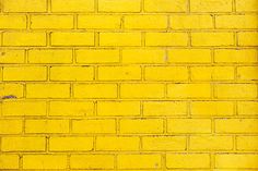 a yellow brick wall that is painted bright yellow