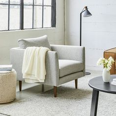 a living room with a chair, table and lamp