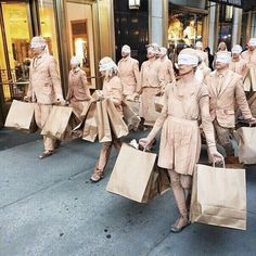 many people are walking down the street with bags on their heads and blindfolds over their eyes