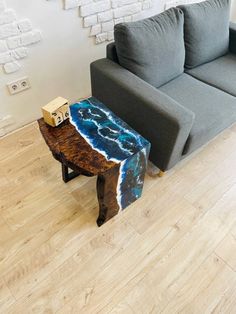 a couch sitting next to a wooden table on top of a hard wood floor