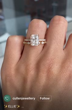 a woman's hand with an engagement ring on it