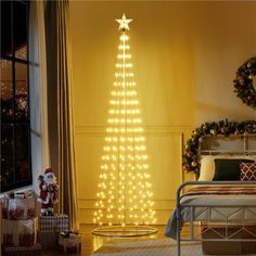 a bedroom decorated for christmas with lights on the tree