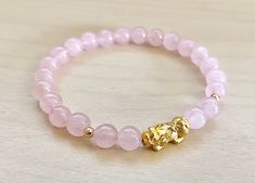 This is Pure Real 24 Karat Gold Pixiu/Natural Rose quartz / real 14k gold beads Real Gold Pixiu - Approximately 13mm x 6mm ( hollow , less than 1 g ) 14 karat Gold Beads Round - Approximately 3mm Natural Rose quartz - Approximately 6mm Hallmark/Stamp 999 for 24k Gold (PIXIU) Please select bracelet size. All are handmade with care .Strung on heavy duty stretchy/elastic. Products and photo may differ/beads color may vary. Bracelet Comes with Storage Bag & Box PIXIU/PIYAO ~ Secures Wealth and G Elegant Gold Crystal Bracelet For Meditation, Gold Rose Quartz Beaded Bracelets As Gift, Spiritual Gold Beaded Rose Quartz Bracelets, Gift Rose Quartz Beaded Bracelets In Gold, Gold Beaded Bracelet With Rose Quartz Round Beads, Gold Beaded Bracelets With Rose Quartz Round Beads, Gold Beaded Bracelets With Rose Quartz, Gold Rose Quartz Beaded Bracelets With Round Beads, Gold Rose Quartz Beaded Bracelets