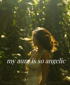 a woman in a white dress is walking through the woods with her hair blowing in the wind