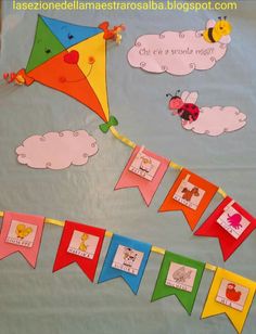 a bulletin board with kites, clouds and animals hanging from it's sides