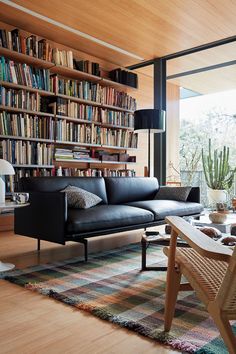 a living room filled with furniture and bookshelves full of bookcases next to a window