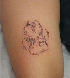 a woman's thigh with flowers and leaves on the side, in black ink