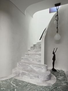 a statue stands in the middle of a marbled room with white walls and stairs