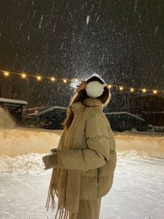 a woman standing in the snow at night