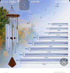 a wind chime with musical notes and trees in the background