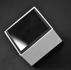 a square metal object on a black surface