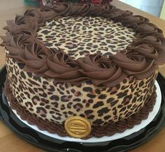 a leopard print cake sitting on top of a wooden table