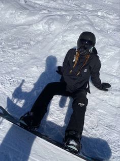 a person sitting in the snow on a snowboard